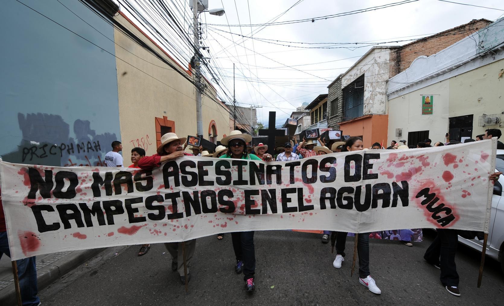 Des membres du Movimiento Unificado Campesino del Aguan (MUCA) manifestent à Tegucigalpa en portant des cercueils symbolisant leurs camarades assassinés | Honduras, 2012 | © AFP/Orlando SIERRA